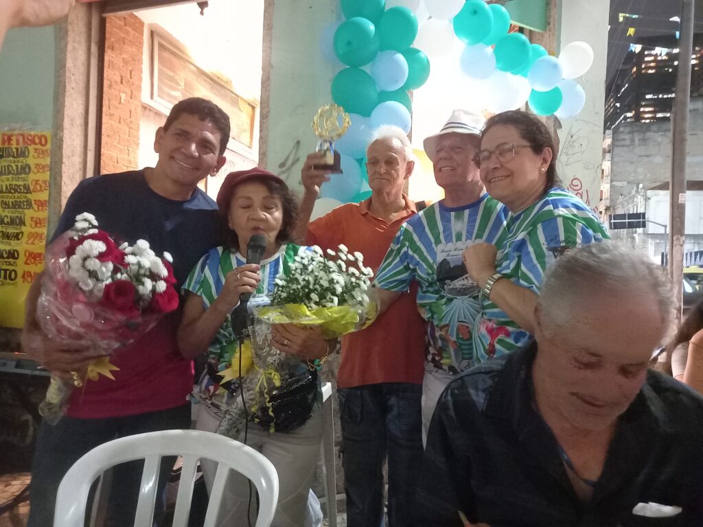 A Diretora de Cerimônia, Deuzimar Salazar, oferecendo flores aos ganhadores do concurso
